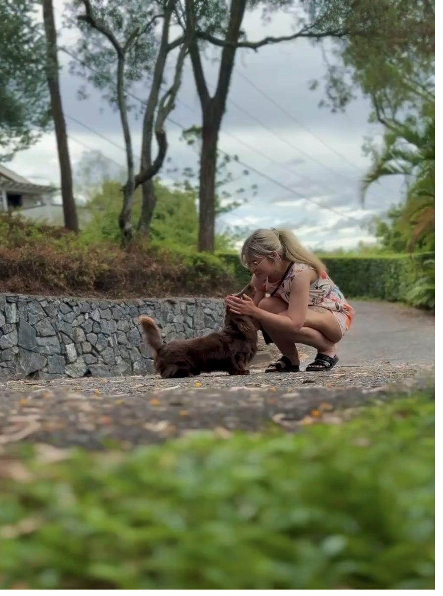 Ash crouching with dachshund outdoors